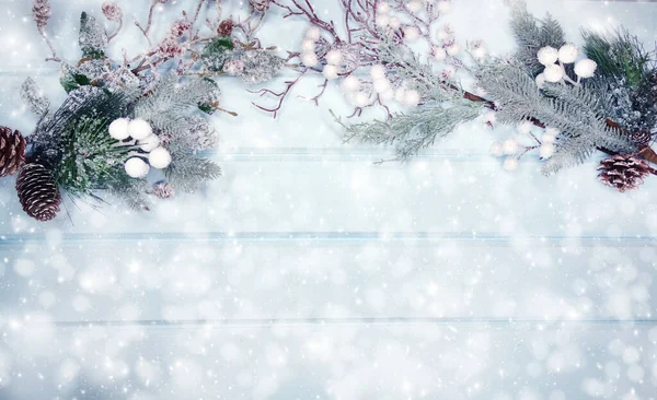 Kış Noel arkaplanı köknar dalları koniler ve mavi ahşap dokuda kar                              