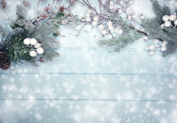 Kış Noel arkaplanı köknar dalları koniler ve mavi ahşap dokuda kar                              