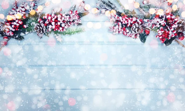 Kış Noel arkaplanı köknar dalları koniler ve mavi ahşap dokuda kar                              