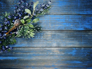 Kış Noel arkaplanı köknar dalları koniler ve mavi ahşap dokuda kar                              