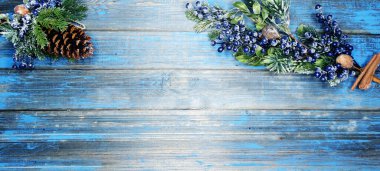 Kış Noel arkaplanı köknar dalları koniler ve mavi ahşap dokuda kar                              