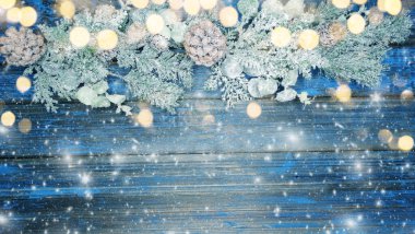 Kış Noel arkaplanı köknar dalları koniler ve mavi ahşap dokuda kar                              