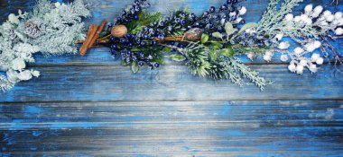 Kış Noel arkaplanı köknar dalları koniler ve mavi ahşap dokuda kar                              