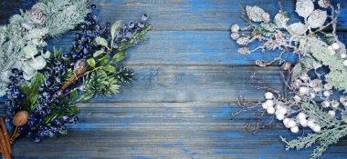 Kış Noel arkaplanı köknar dalları koniler ve mavi ahşap dokuda kar                              