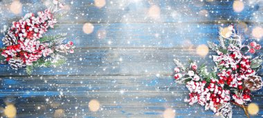 Kış Noel arkaplanı köknar dalları koniler ve mavi ahşap dokuda kar                              