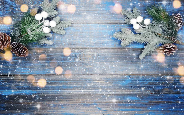 Kış Noel arkaplanı köknar dalları koniler ve mavi ahşap dokuda kar                              