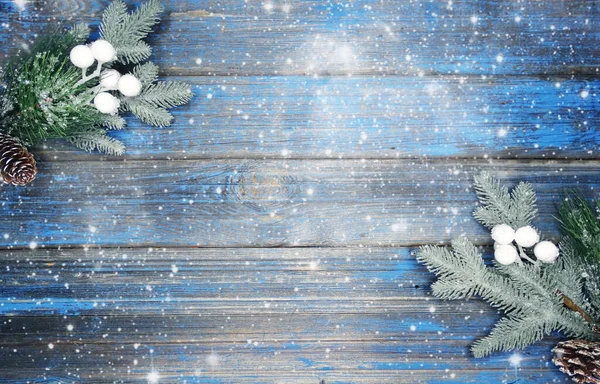 Kış Noel arkaplanı köknar dalları koniler ve mavi ahşap dokuda kar                              