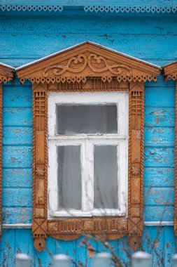 Zencefilli kekin ahşap kesimi. Eski mavi ahşap bir evin pencere süslemesi.