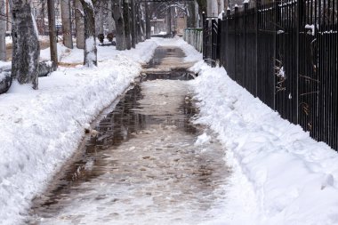 Karlı ve su birikintili yol, buzlar çözülür..