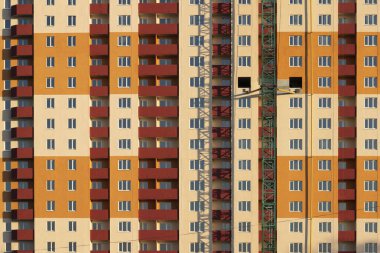 İnşaat önü manzaralı yüksek katlı bir binanın parlak çizgili cephesi