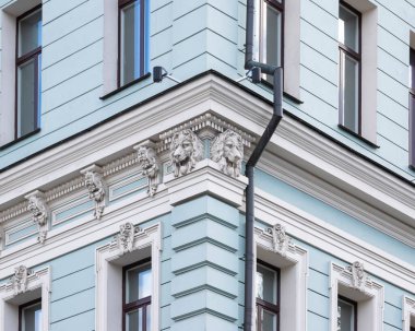 Binanın köşesinde. Korniş aslan başlarıyla süslenmiş.. 