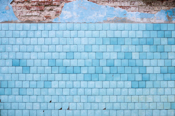 Старая кирпичная стена с голубыми сказками и штукатуркой