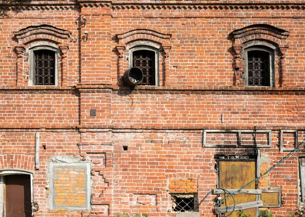 Eski bir kırmızı tuğla binanın ön cephesi. Ön görünüm.