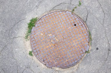 Şehir caddesinde paslı metal rögar kapağı