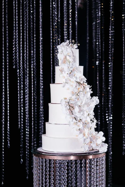 Pastel de boda de seis niveles decorado con orquídeas blancas. Pastel de boda en el fondo oscuro brillante — Foto de Stock