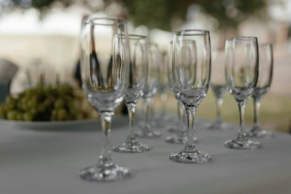 Puste kieliszki do szampana przy białym stole z miejscem na tekst. Szklanka wina. Impreza alkoholowa — Zdjęcie stockowe