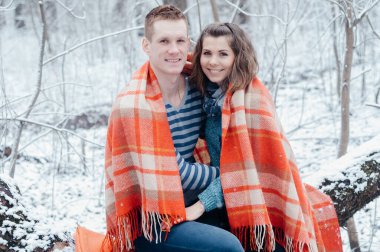 Kareli kumaşa sarılmış, kış ormanında oturan aşık bir çift. Erkekler güzel kadınlara sarılırlar. Ekoseye sarılmış orta yaşlı erkek ve kadınlar. Aşk hikayesi.