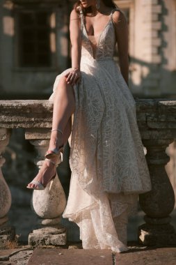 Eski korkuluklarda oturan yüzü olmayan gelin, bacak bacak üstüne atmış mutlu gelin. Yüksek kalite fotoğraf