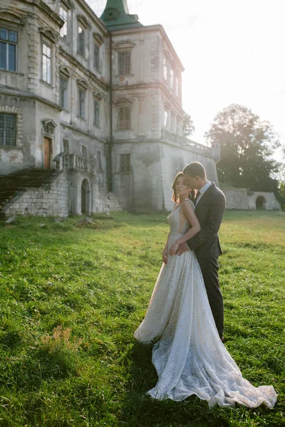 Piękna panna młoda i pan młody stojący przed starym zamkiem. Małżeństwo. Zdjęcie ślubne — Zdjęcie stockowe