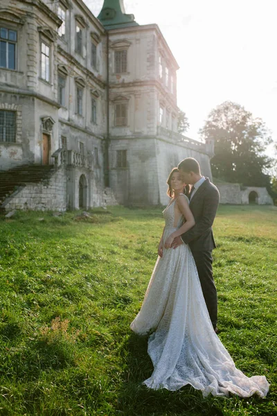 Hermosos novios de pie frente al viejo castillo. Pareja de bodas. Boda foto — Foto de Stock