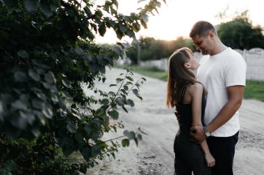  Gülümseyen adam ve kadın. Karı koca gün batımında kucaklaşıyorlar. Sokaktaki mutlu çift