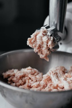 Kıyma makinesinden dökülen etin yakın çekimi. Doğranmış et.