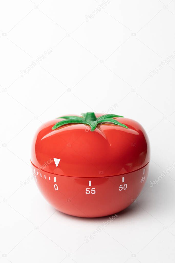 Pomodoro timer - mechanical tomato shaped kitchen timer for cooking or studying on the grey background. Place for your text.