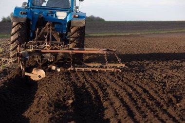 Tractor plow that plows the land close-up. Place for your text