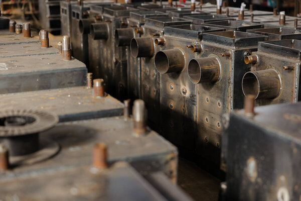 Металлические детали и компоненты котла аккуратно расположены в живом цехе, демонстрируя сложный производственный процесс.