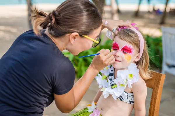 Young woman makes the child's vivid face painting — Stock Photo, Image