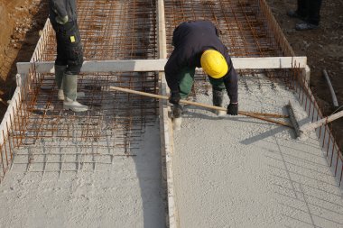 Bir beton zemin sarı kask ile şantiye çalışanları