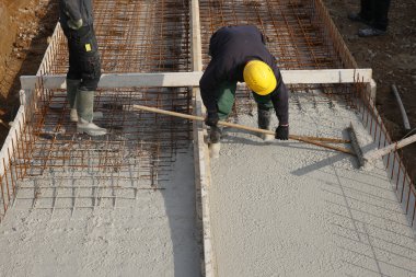 Constructon workers with yellow helmet on a concrete floor clipart