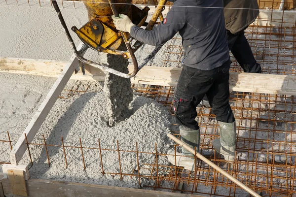 Trabalhadores constructon com capacete amarelo em um piso de concreto — Fotografia de Stock
