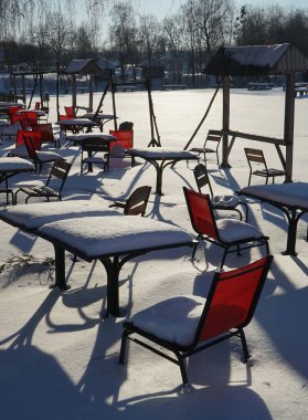 Güneşli bir günde karla kaplı banklar.