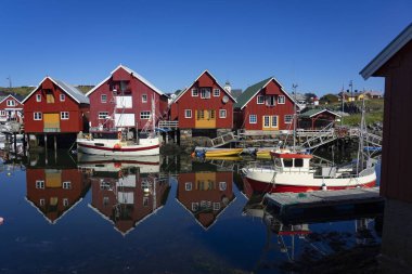 Güneşli bir günde rıhtımda balıkçı tekneleri. Güzel evleri olan küçük bir balıkçı köyündeki Marina..