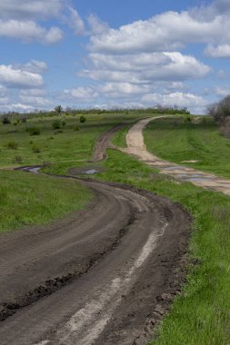 Güneşli bir günde tepenin zirvesine çıkan iki farklı yol ve güzel bulutlar.