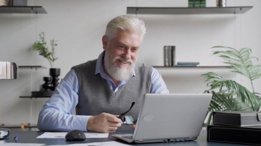 Mutlu gri sakallı yaşlı bir adam görevini tamamladı ve ellerini kaldırarak zafer kazandı.