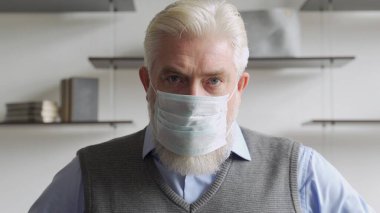 Tıbbi maske takmış yaşlı bir adamın portresini kapat..