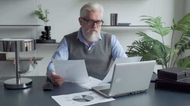 Senior volwassen zakenman werken gestresst en gefrustreerd op kantoor computer laptop bureau ziet er moe en overweldigd in werkproblemen en overwerk — Stockvideo