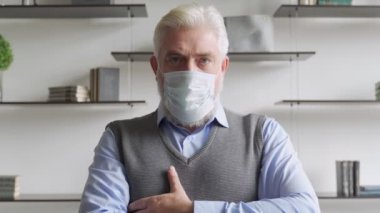 Tıbbi maske takmış yaşlı bir adamın portresini kapat..