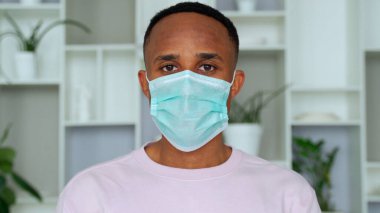 Young handsome african man wore face mask preventing, prevented himself from the outbreak in his society. clipart