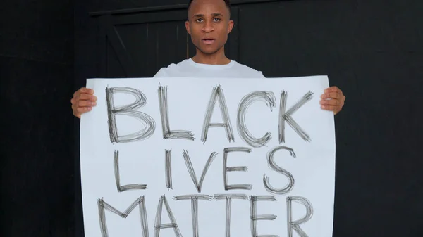 Plakat BLACK LIVES ma znaczenie w rękach czarnego człowieka. — Zdjęcie stockowe