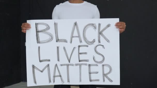 Плакат "ЧЕРНЫЙ ЖИЗНЬ" в руках черного мужчины. — стоковое видео
