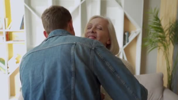 Ältere Mutter umarmt ihren Sohn zu Hause, Lifestylekonzept. — Stockvideo