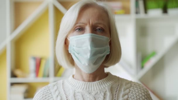 安全与大流行概念.为防止室内病毒而戴防护口罩的老年妇女的肖像 — 图库视频影像