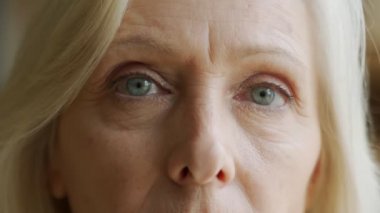 Yaşlı kadının yüzü ve gözleri. Yaşlı kadının yüzünde büyük kırışıklıklar var. Yüzünü kapat.