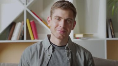 Ofisteki kameraya bakan kendinden emin genç iş adamı.