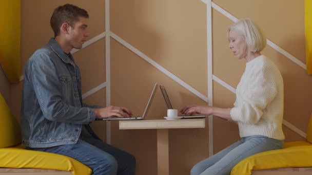Pengusaha lansia berkomunikasi dengan pengusaha paruh baya, mendiskusikan masalah kerja, melihat layar laptop, manajemen mendistribusikan tugas kepada karyawan — Stok Video