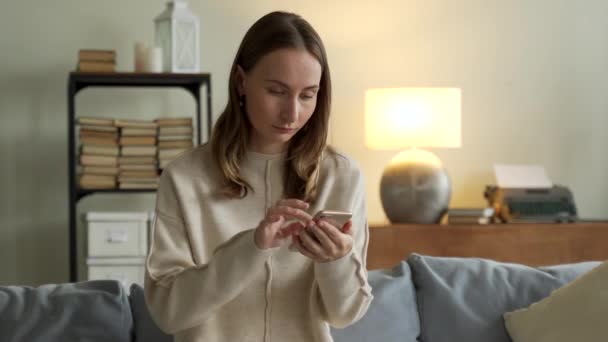 Mujer recibiendo buenas noticias de notificación a través del teléfono móvil. Chica celebrando la victoria en línea usando el teléfono celular — Vídeos de Stock