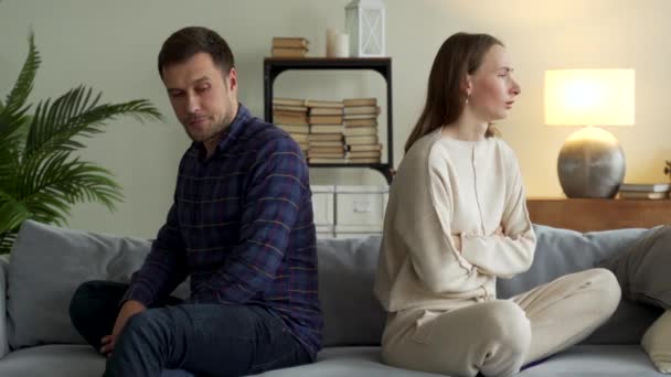 Rozzlobený pár sedět odděleně na gauči ignorovat vyhnout se mluvit po rodinné hádce nedorozumění. Nešťastní manželé muž a žena myslí na rozvod nebo rozchod — Stock video